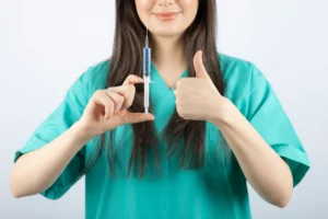 Gambar seorang perawat profesional sedang memegang jarum suntik - Perawathomecare